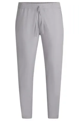 Pantalones tapered fit de tejido elástico repelente al agua