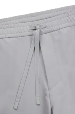 Pantalones tapered fit de tejido elástico repelente al agua